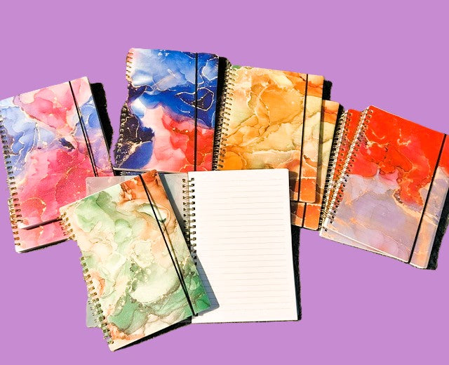 Collection of marble ink spiral notebooks in multiple colorways