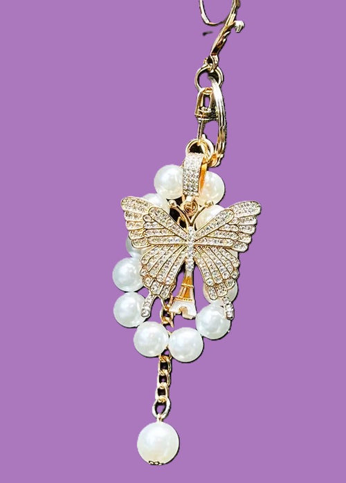 Crystal butterfly and pearl keychain charm on purple background