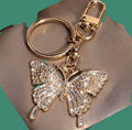 Gold crystal rhinestone butterfly keychain on teal background